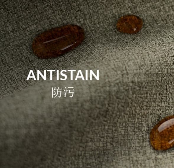 Brown liquid droplets bead on textured grey fabric with 'ANTISTAIN' text, demonstrating stain resistance.